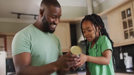 Feliz-Padre-E-Hija-Afroamericanos-Leyendo-La-Etiqueta-En-Lata-En-La-Cocina