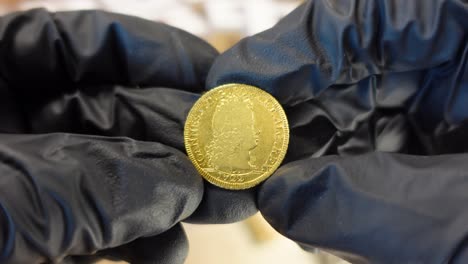 collector examining portuguese ancient golden coin