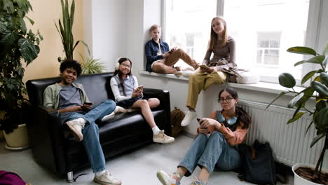 group of diverse teenagers relaxing in a school lounge area
