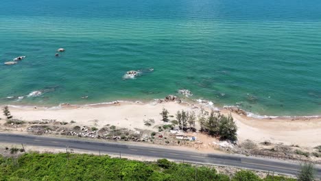 aerial view dolly of the forest, road and the sea in ho tram