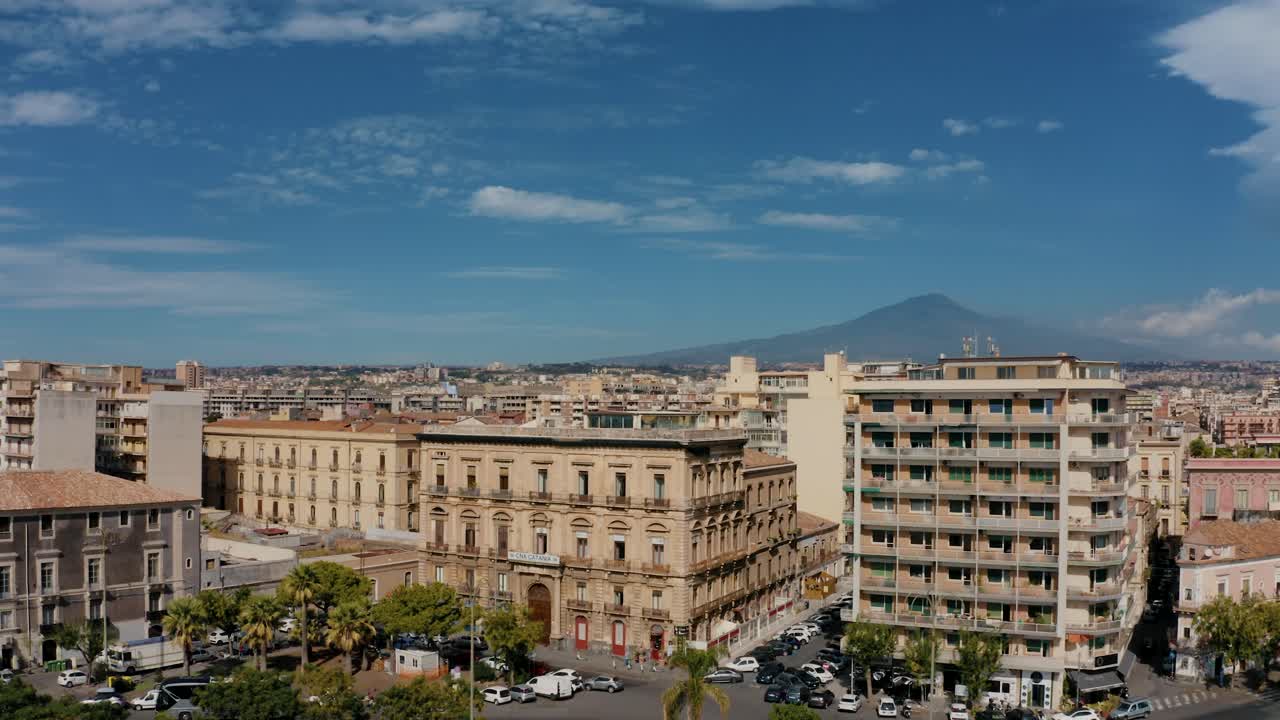Drone shot of residential buildings in Catania with volcano Etna in the background. Urban area. Streets with cars.