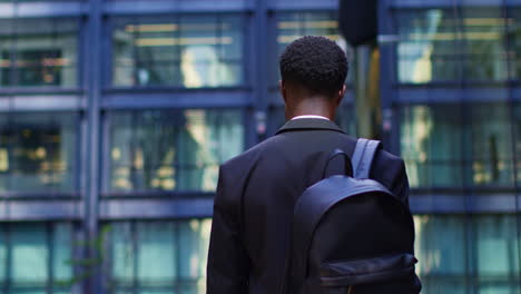 Rear-View-Of-Businessman-Wearing-Backpack-Walking-To-Work-In-Offices-In-The-Financial-District-Of-The-City-Of-London-UK-2