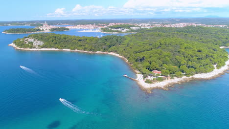 Rovinj,-Croatia-aerial-tracking-shot-looking-towards-golden-cape-and-lone-bay-above-the-sea