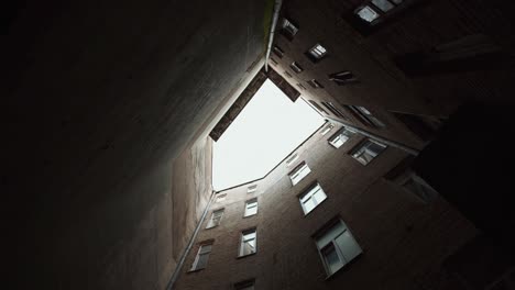 View of old building in tight yard. Natural daylight. Cloudy weather. Looking up