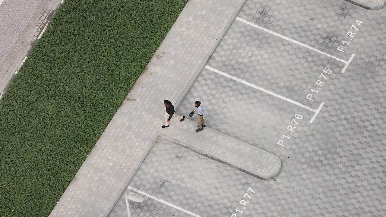 Two men walking in a parking lot