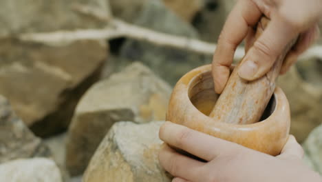 hands using a mortar and pestle