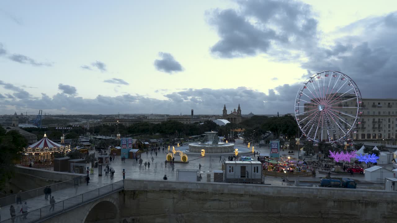 timelapse del país de las maravillas invernal con vistas a la entrada a la valletta, convertido en un pueblo navideño con una noria gigante y otras atracciones navideñas