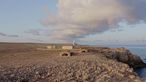 Long-aerial-approach-towards-the-Punta-Nati-Lighthouse-in-the-north-of-Menorca,-Spain