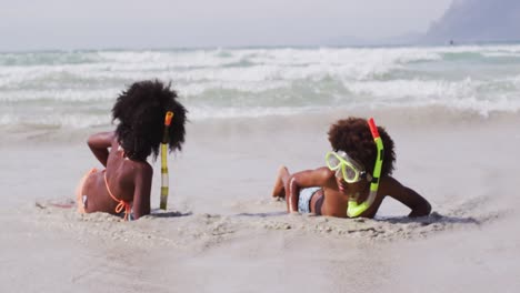 African-american-children-wearing-scuba-goggles-playing-at-the-beach