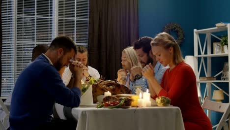 Group of friends praying on Thanksgiving day celebration