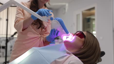 professional teeth whitening treatment with bright led light in modern dental office setting.