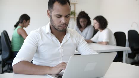 Focused-programmer-working-at-open-space-office