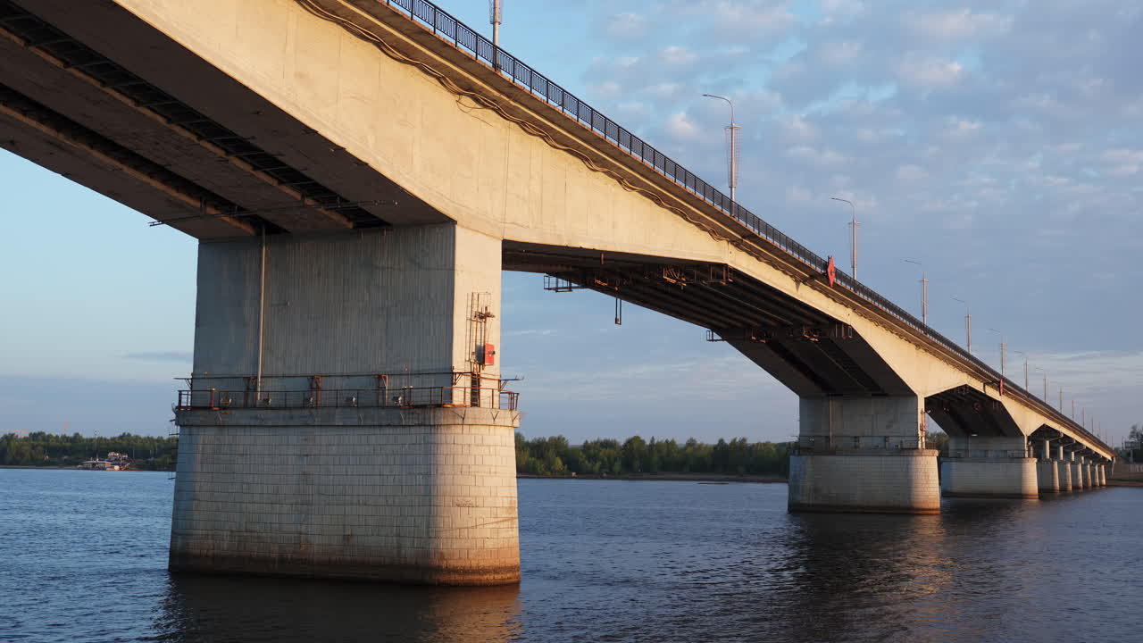 Large Concrete Bridge Spanning Over a River at Sunset