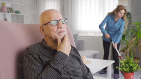 Nachdenklicher-Alter-Mann-Und-Alte-Frau-Putzen-Im-Hintergrund.