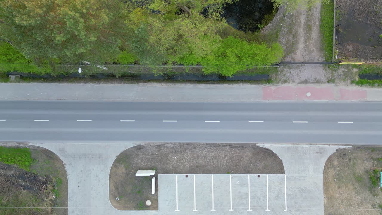 vuelo aéreo recto sobre el tráfico en la calle principal de una pequeña ciudad