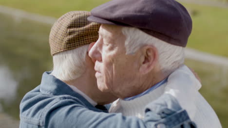 close up shot of loving elderly couple dancing outdoors and hugging in city park