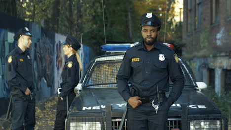 Retrato-De-Un-Policía-Serio-Y-Apuesto-Con-Uniforme-Mirando-La-Cámara-Al-Aire-Libre