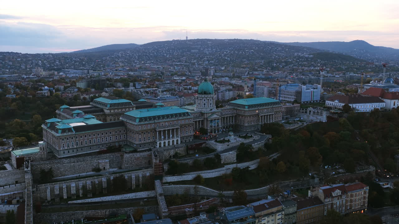 A sweeping aerial of Buda Castle and the surrounding hills, revealing the heart of historic Budapest along the Danube River