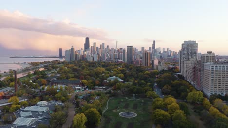 Increíble-Disparo-Aéreo-Sobre-El-Horizonte-Del-Parque-De-Chicago-En-La-Puesta-De-Sol-De-Fondo