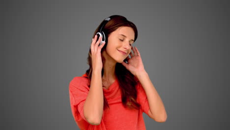 woman listening to music on grey background