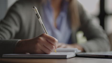 close-up pen writes a lecture in a notebook notebook. student writes with pen on paper