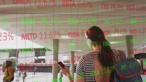 Animation-of-trading-board,-rear-view-of-biracial-woman-listening-music-while-walking-in-college