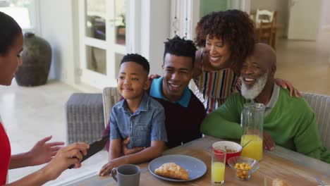 Afroamerikanisches-Mädchen,-Das-Ein-Selfie-Macht,-Während-Es-Mit-Seiner-Familie-Zu-Hause-Frühstückt