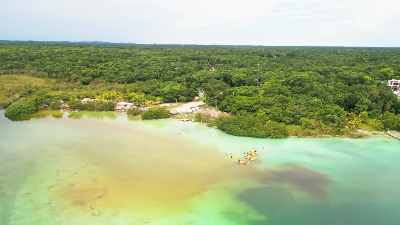 Luxury Hotels And Thatched Roof Huts Along The Lagoon In Bacalar, Quintana Roo, Mexico. Aerial Drone Shot