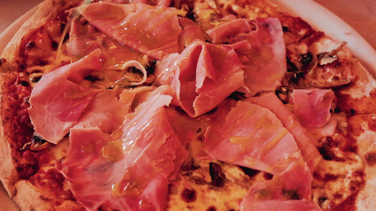 Overhead shot of a freshly baked pizza generously topped with thin slices of prosciutto