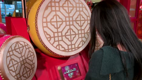 a woman plays a traditional drum at a chinese new year theme installation event for the chinese lunar new year in hong kong