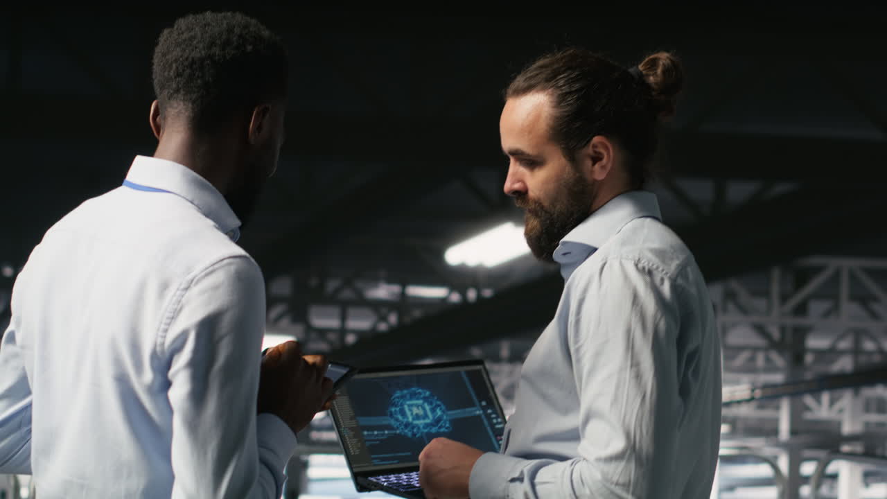 Data center team leader and worker reviewing performance dashboards of AI