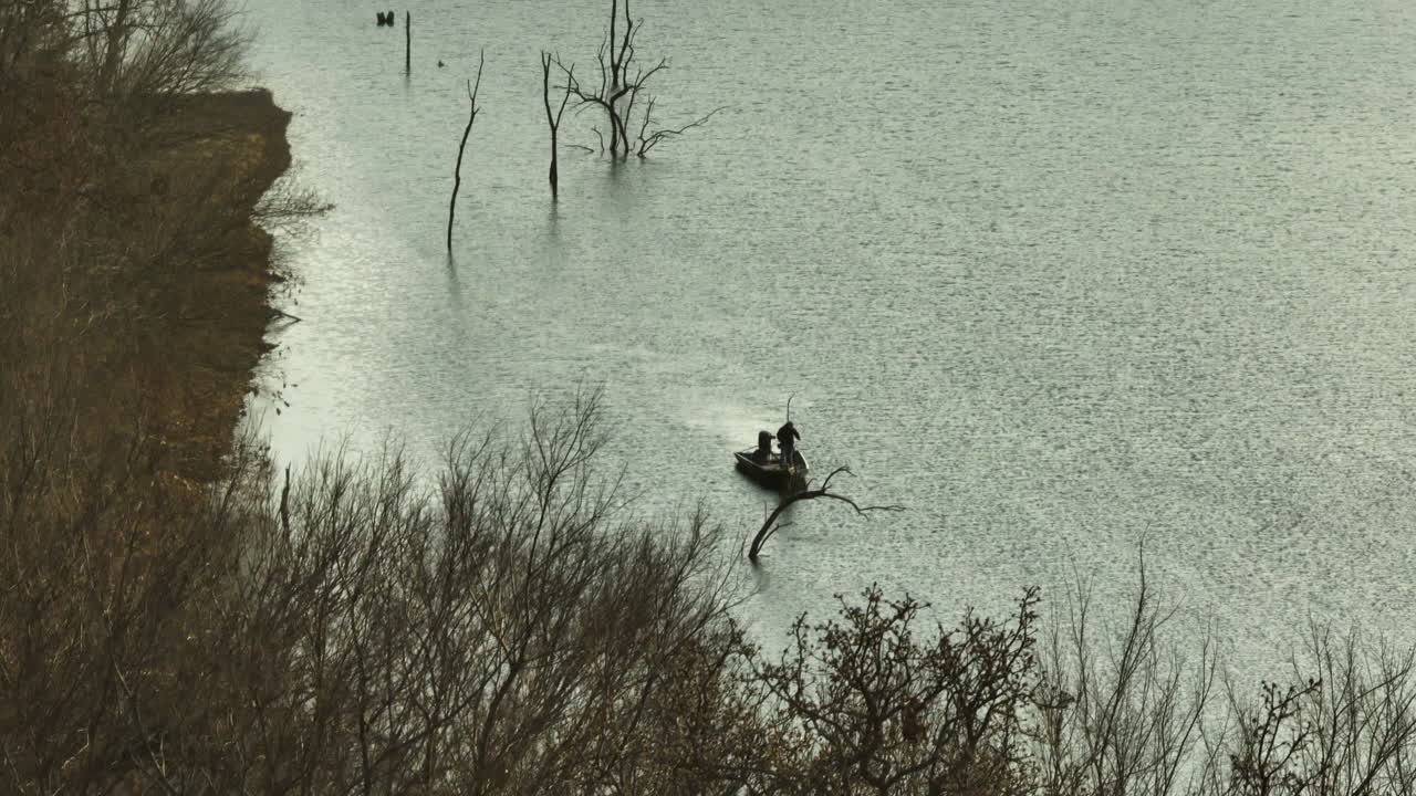 Una veduta di un uomo in barca che pesca al lago Swepco nella contea di Benton, Arkansas, USA.