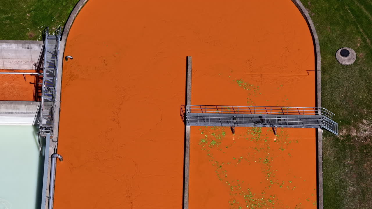 Wastewater treatment facility orange color polluted contaminated purification station, aerial above