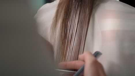 vista de mano del cabello largo cortado por el peluquero