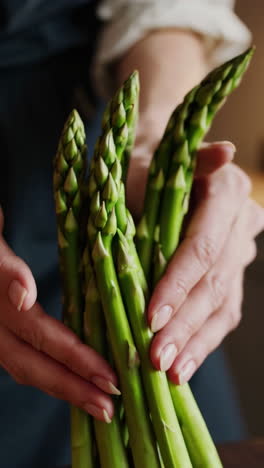hands holding and arranging fresh green asparagus
