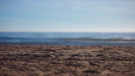 empty beach with focus shifting from the sand into the sea