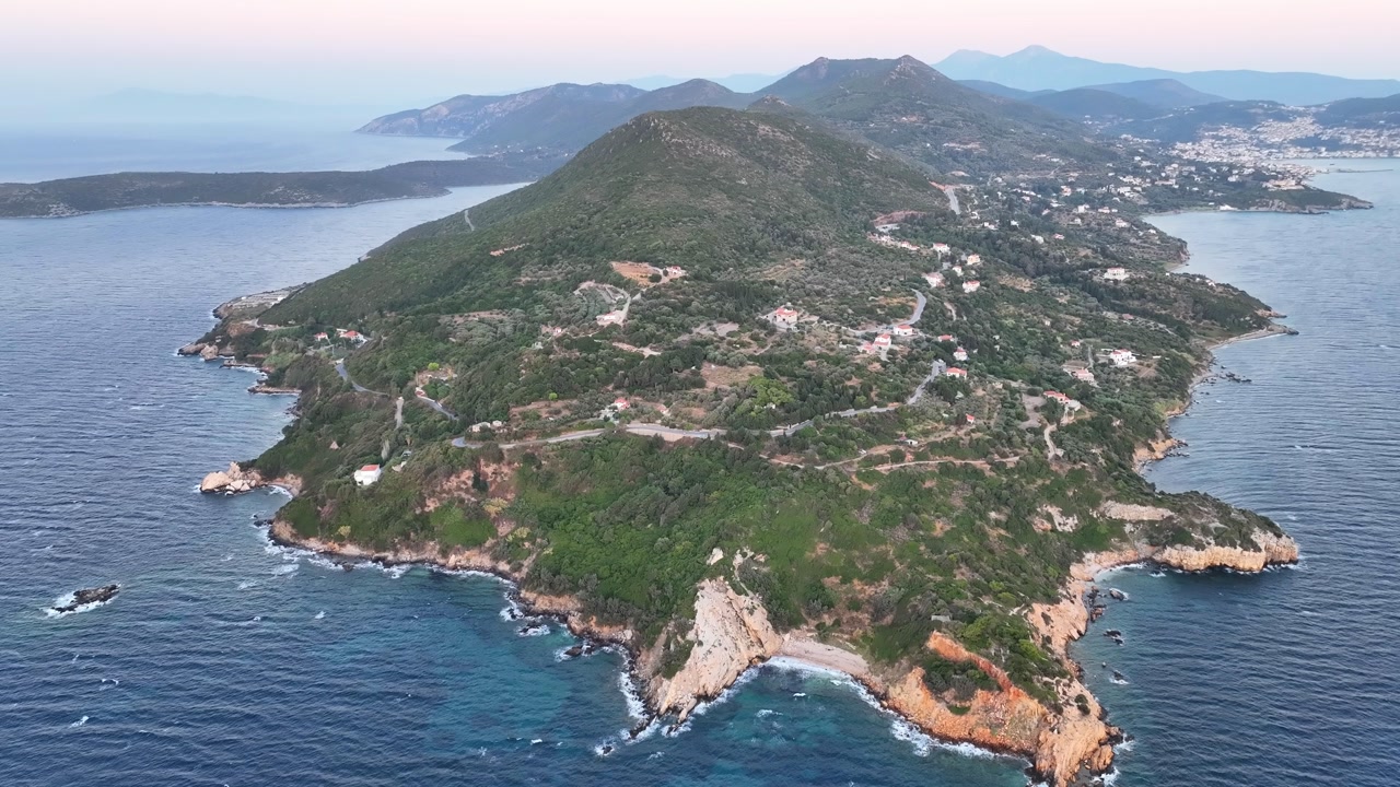 Aerial footage over a peninsula and the sea at susnset