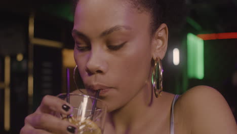 Close-Up-Of-A-Beautiful-Girl-Drinking-Cocktail-While-Sitting-At-Bar-Counter