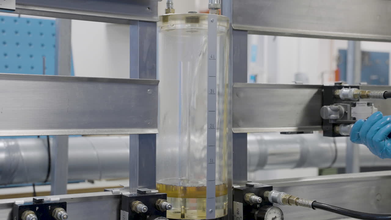 primer plano: trabajador en una planta química probando la presión hidráulica del líquido de aceite