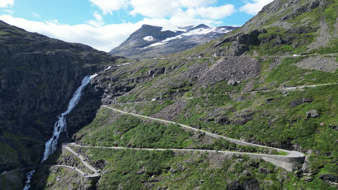 trollstigen carretera de montaña en noruega - los coches conducen ruta turística con cascada y curvas estrechas - pedestal