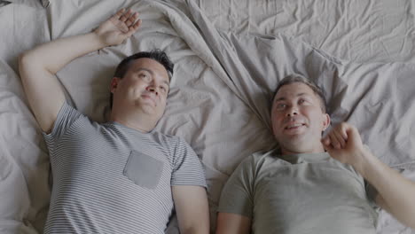 two men relaxing together on a bed