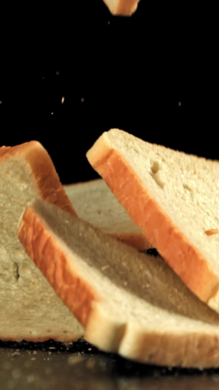 Fresh White Bread Slices Falling in Slow Motion on Black Background