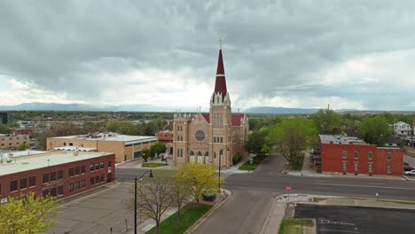 Frontal establishing view of tan cathedral in Pueblo Colorado surrounded by empty parking lots