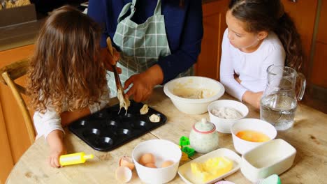 Siblings-preparing-cookie-with-grandmother-in-kitchen-4k