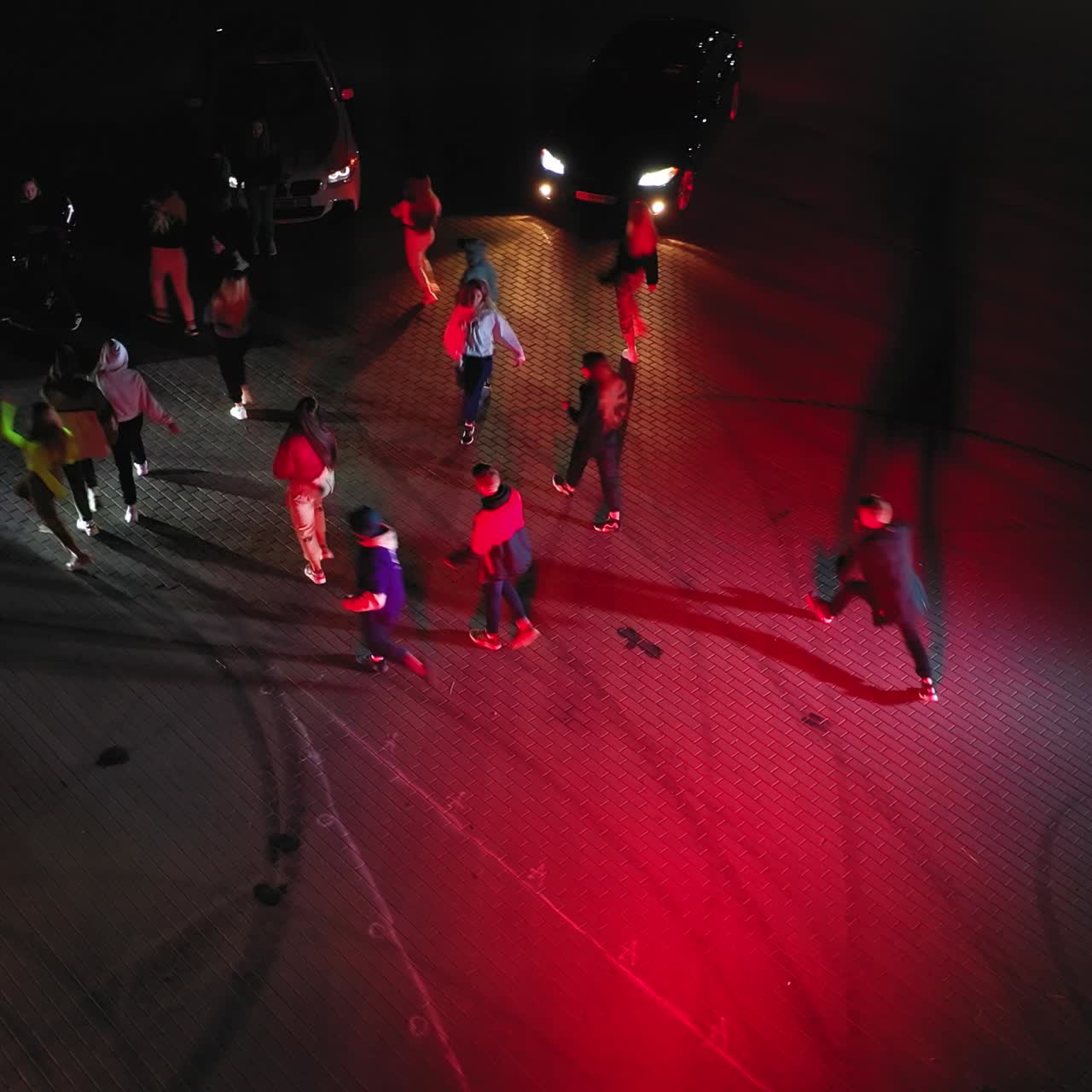 Sportive happy teenage people dance hip hop. Band dancing in flashlights. Race cars at backdrop. Top view