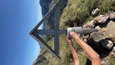 mano caucásica vuelve a poner un libro de la cumbre en un pico en suiza, video vertical