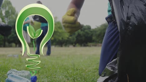 Animación-Del-Logo-De-La-Bombilla-Verde-Sobre-Un-Hombre-Caucásico-Feliz-Limpiando-Con-Voluntarios-En-El-Campo