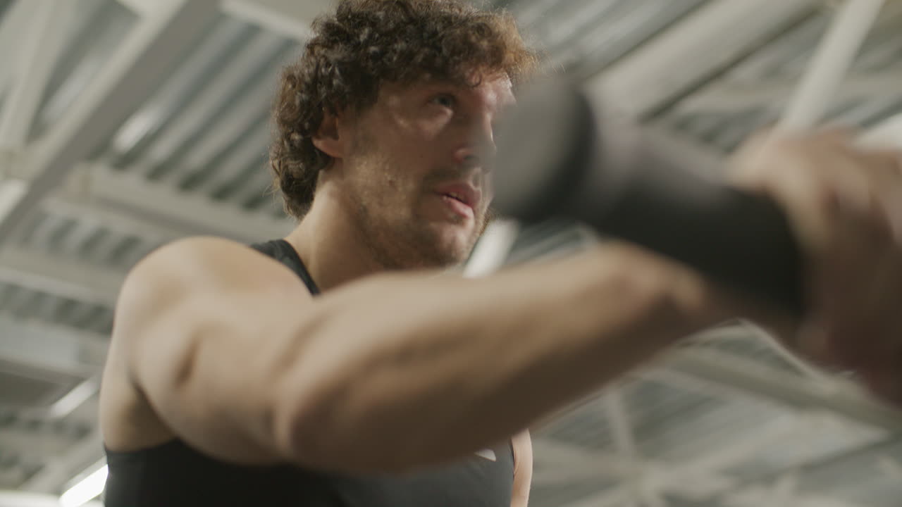 Muscular Athlete Doing Intense Air Bike Workout at Gym
