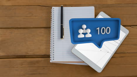 a tablet and a notebook on a desk with a profile icon for social media