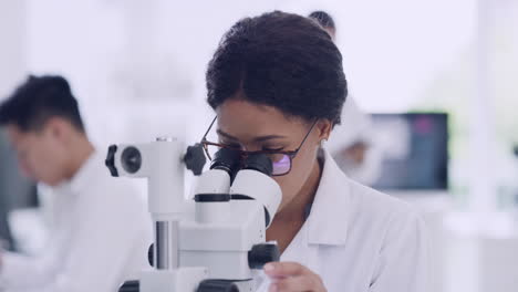 female scientist using a microscope with glasses